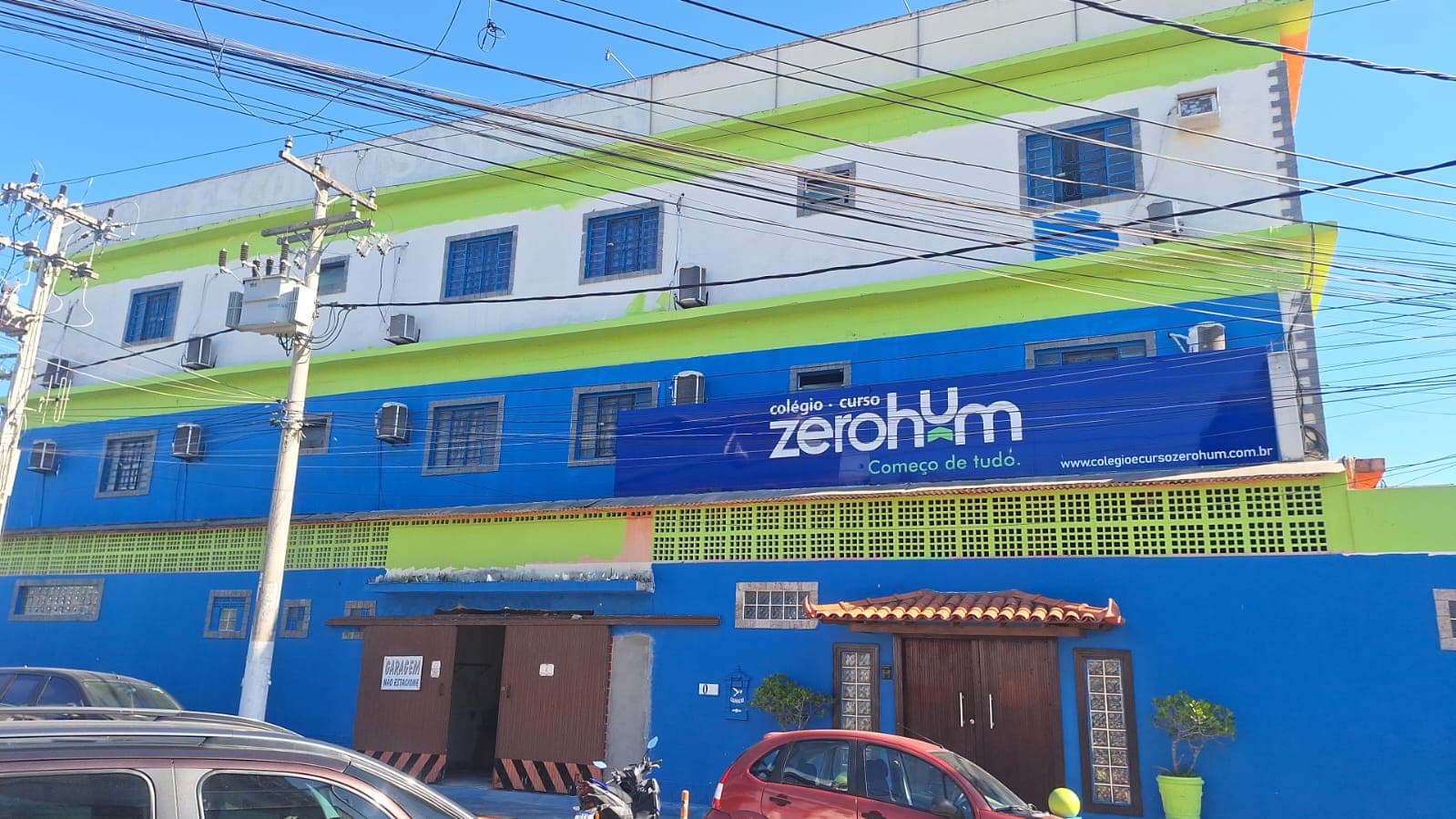 Fachada azul da unidade Cabo Frio do Colégio e Curso Zerohum, com a placa da escola
