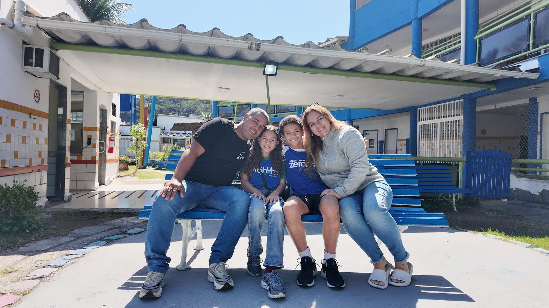 Família sentada num banco do pátio de uma unidade da Zerohum